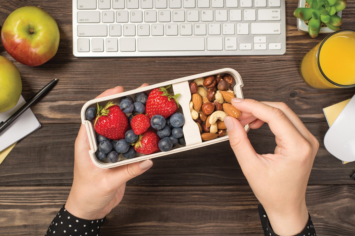 First person top view photo of woman's hands holding lunchbox with healthy meal.